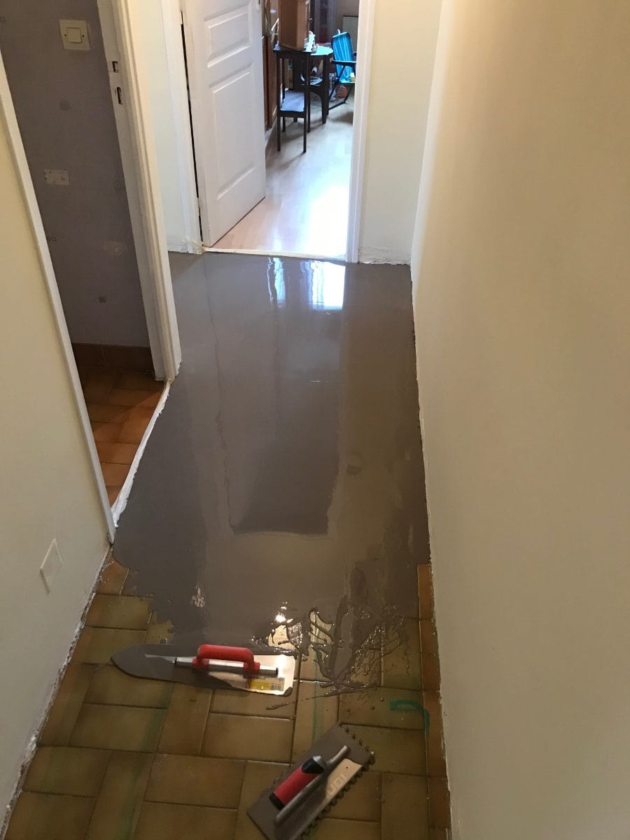 Parquet sur carrelage : poser un sol neuf sans casser l’ancien, chantier à Frégouville 1 - Medale Peinture parquet sur carrelage : ragréage autolissant coulé sur l'ancien carrelage d'un couloir à Frégouville