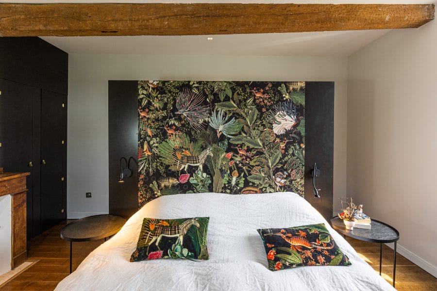 Poutre apparente et tête de lit noire - Médale Peinture poutre apparente au-dessus d’une tête de lit noire dans une chambre rénovée